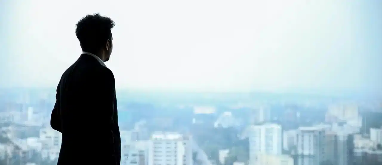 A picture of a businessman looking down the city