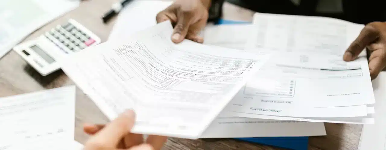 A man hands over a document to a woman