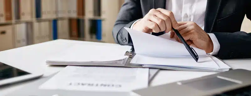 A photo of a female lawyer sitting at a table with lots of documents to file a Recognition of Foreign Divorce case in the Philippines