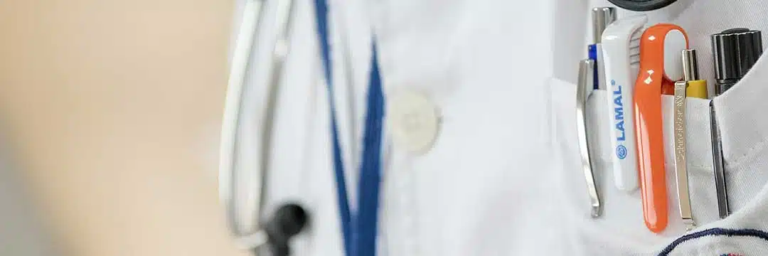 Doctor's white coat with stethoscope and pens