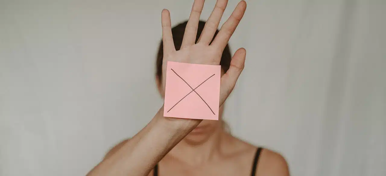 A woman with a sticky post on her hand with an X