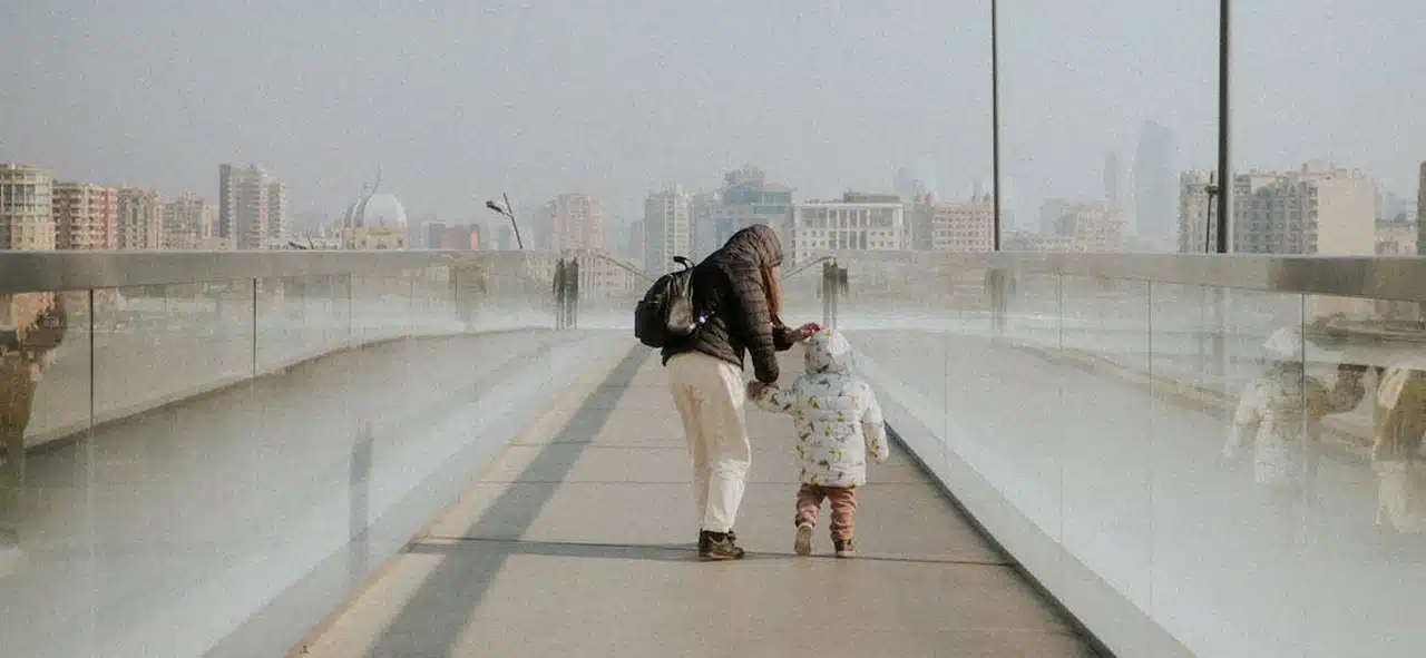 A woman and a little boy walking on an empty street