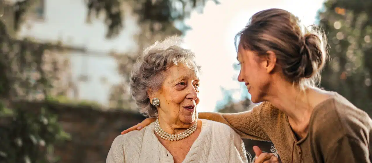 A woman speaking with an older woman